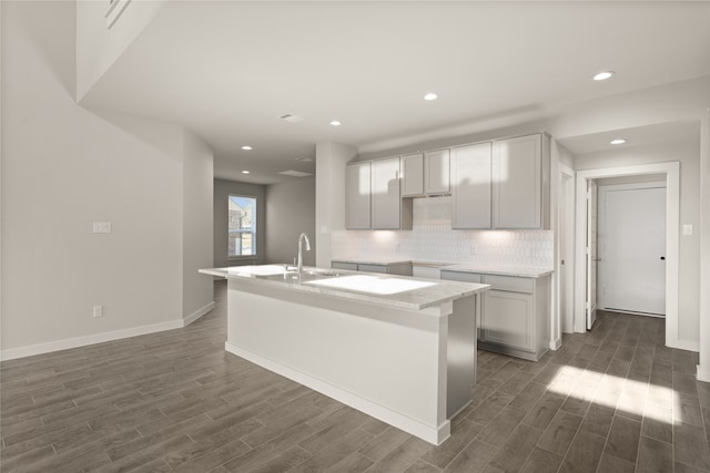 kitchen featuring gray cabinets, a kitchen island with sink, sink, and dark wood-type flooring