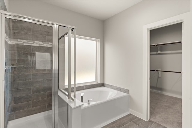 bathroom with wood-type flooring and shower with separate bathtub