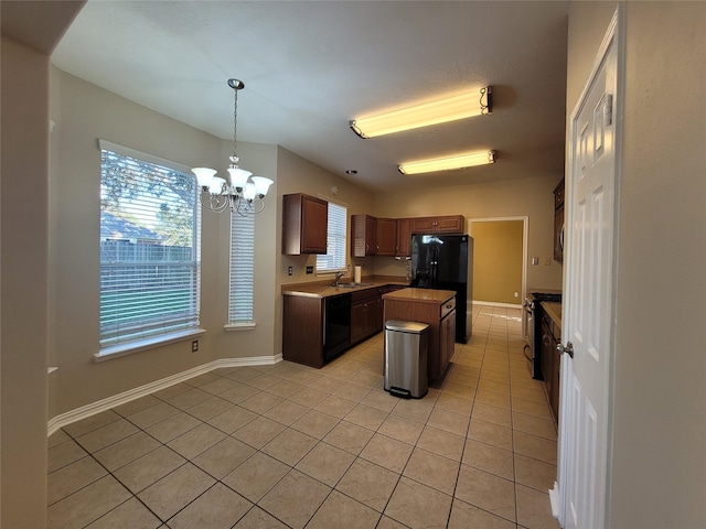 kitchen featuring black appliances, decorative light fixtures, a center island, and light tile patterned floors