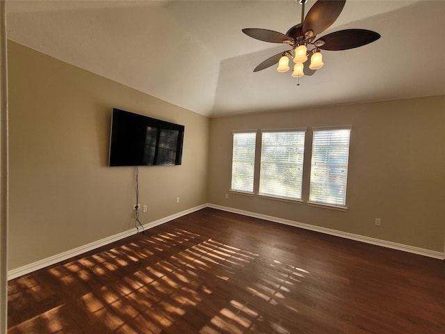 empty room featuring ceiling fan, dark hardwood / wood-style floors, and vaulted ceiling