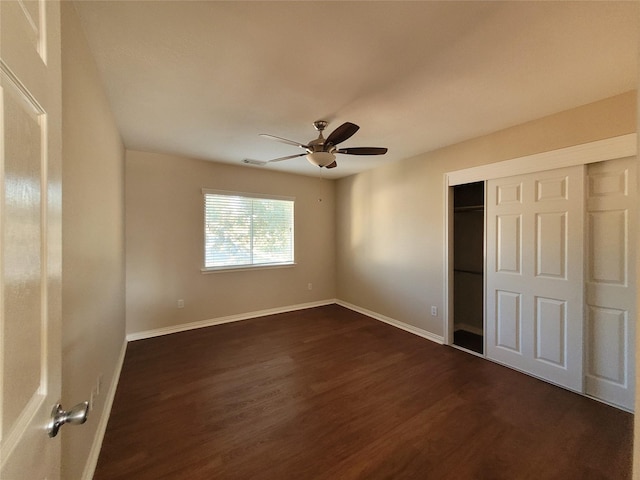 unfurnished bedroom with ceiling fan, dark hardwood / wood-style flooring, and a closet