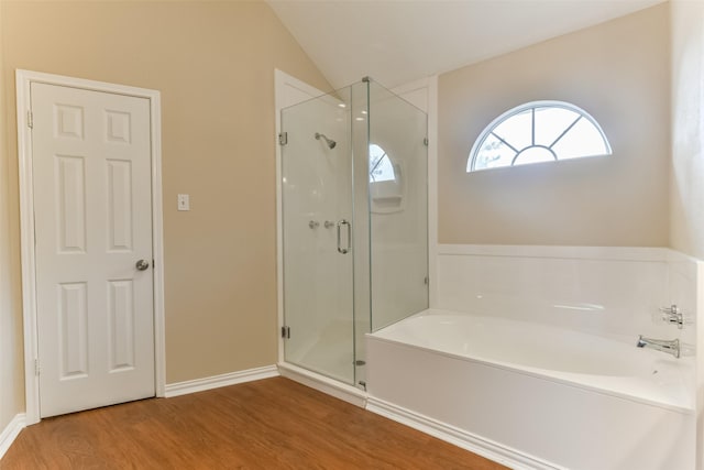 bathroom featuring wood-type flooring, shower with separate bathtub, and lofted ceiling