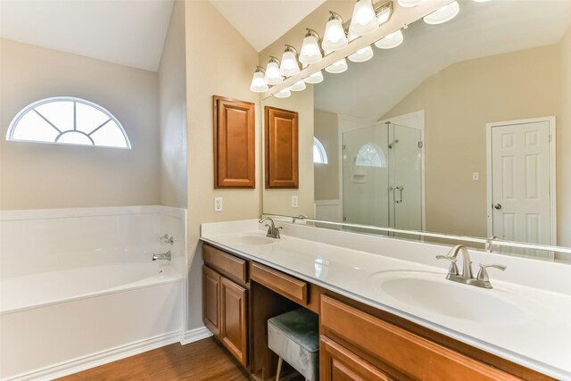 bathroom with plus walk in shower, vanity, hardwood / wood-style flooring, and vaulted ceiling