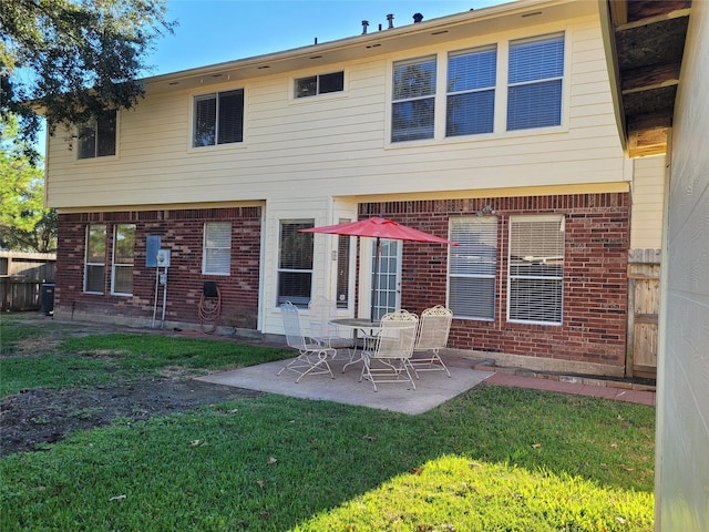 rear view of house featuring a lawn and a patio area