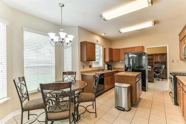 kitchen with hanging light fixtures, light tile patterned floors, a chandelier, a kitchen island, and black appliances