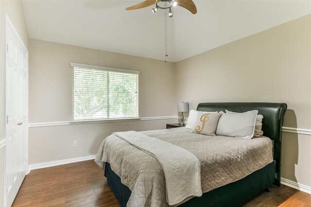 bedroom with dark hardwood / wood-style flooring, a closet, and ceiling fan