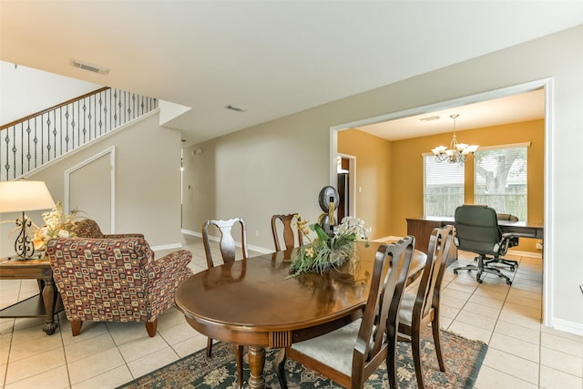 tiled dining room with an inviting chandelier