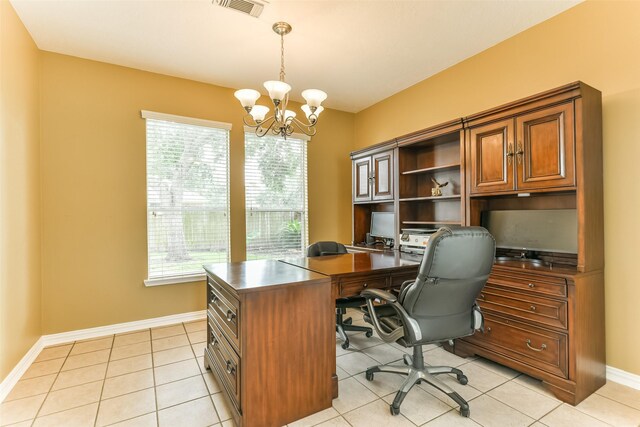 office featuring light tile patterned floors, a healthy amount of sunlight, and an inviting chandelier