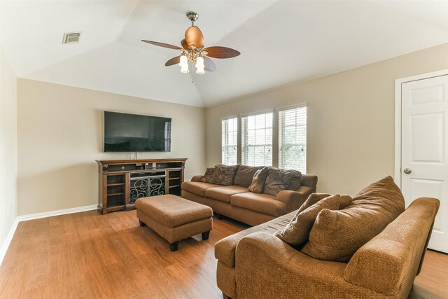 living room with hardwood / wood-style flooring, vaulted ceiling, and ceiling fan