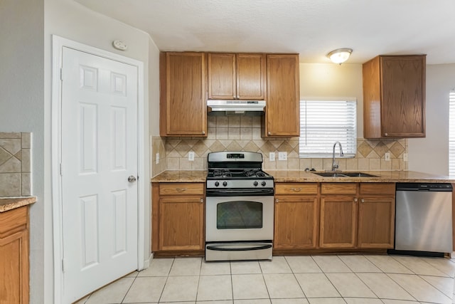 kitchen featuring light stone countertops, appliances with stainless steel finishes, tasteful backsplash, and sink