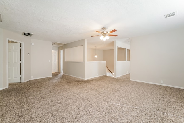 carpeted spare room featuring ceiling fan and a textured ceiling