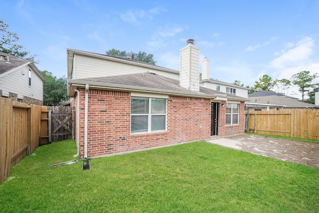 rear view of property featuring a patio and a lawn