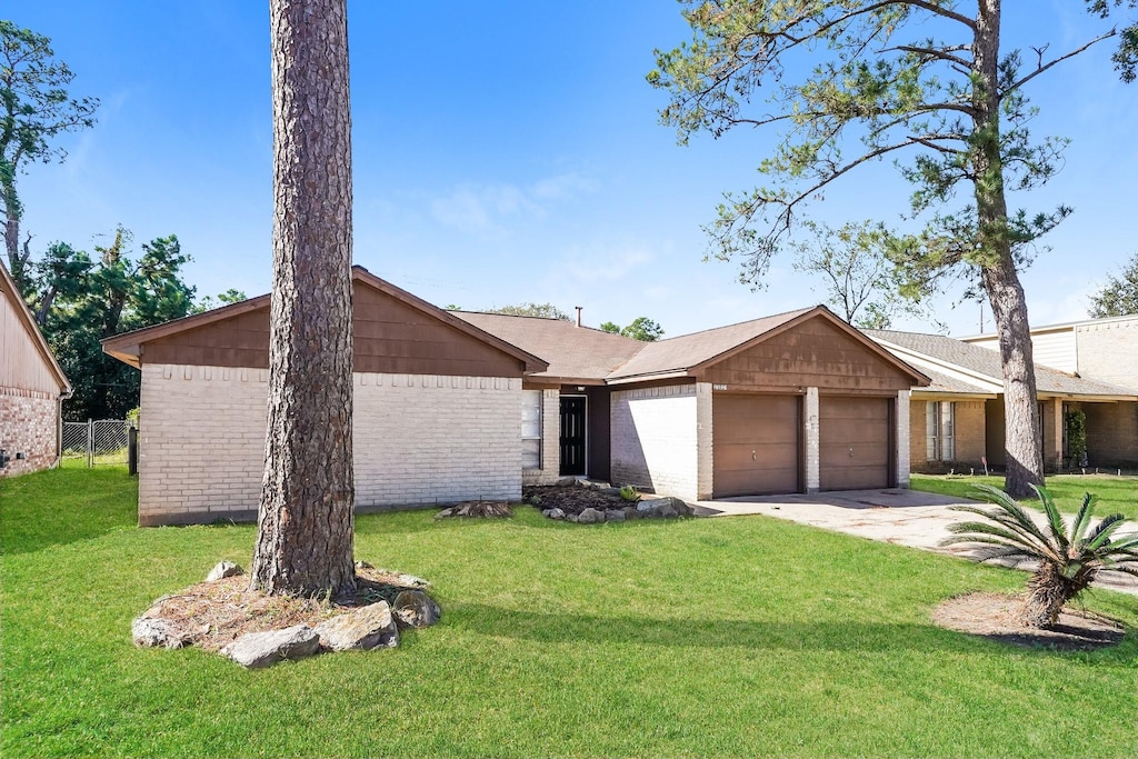 ranch-style home featuring a garage and a front lawn