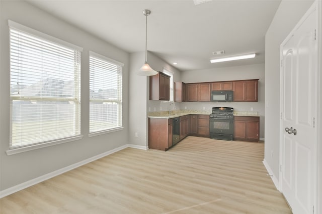 kitchen with sink, light hardwood / wood-style floors, hanging light fixtures, and black appliances