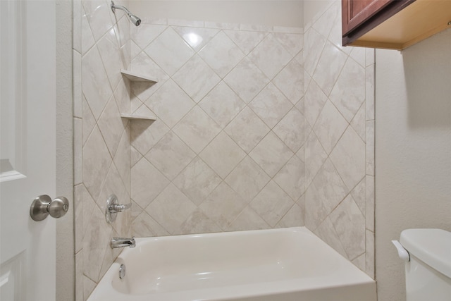 bathroom featuring toilet and tiled shower / bath