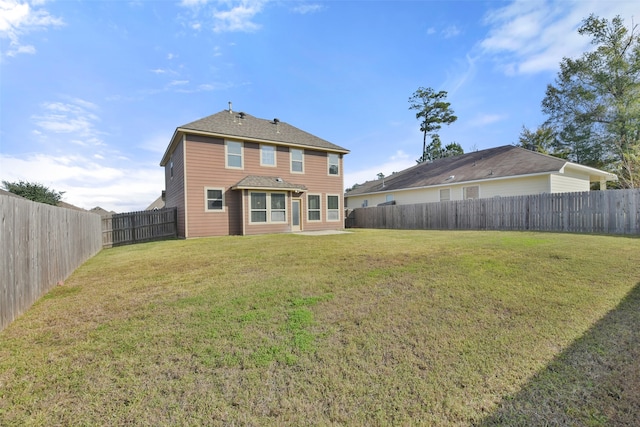 rear view of house featuring a yard