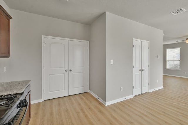 kitchen with ceiling fan, light hardwood / wood-style floors, and stainless steel range