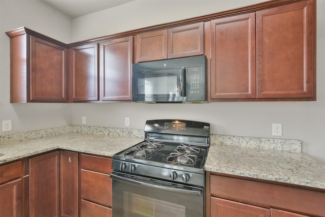 kitchen with light stone counters and black appliances