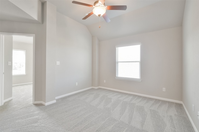 empty room featuring ceiling fan, light colored carpet, and lofted ceiling