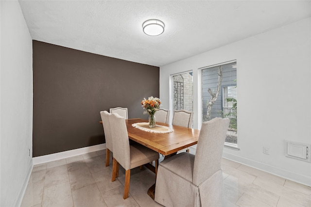 tiled dining room with a textured ceiling