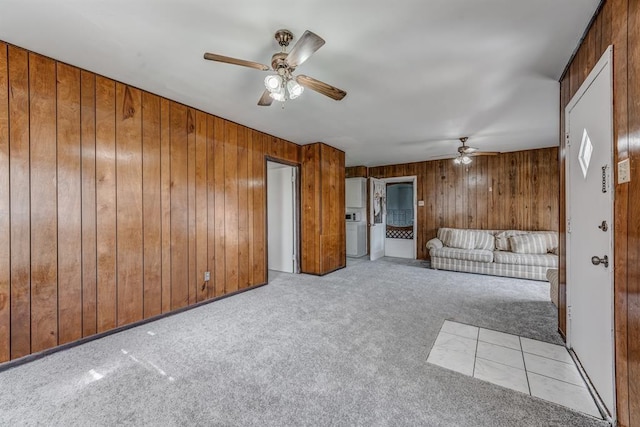 unfurnished living room featuring light colored carpet and wooden walls