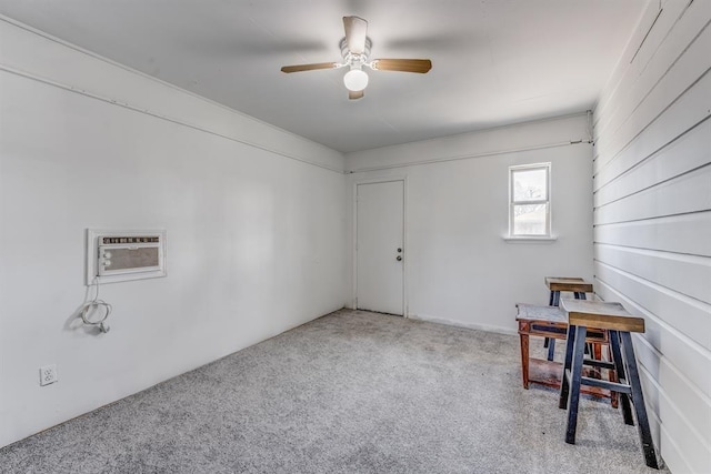 interior space featuring light carpet, a wall unit AC, and ceiling fan