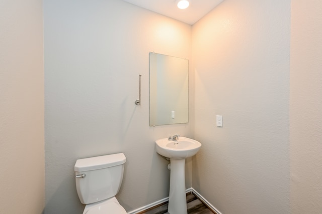 bathroom featuring wood-type flooring and toilet