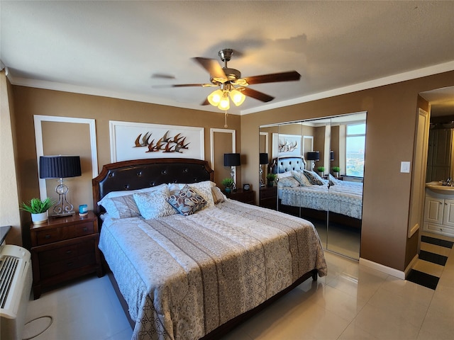 tiled bedroom featuring ensuite bath, ceiling fan, a closet, and ornamental molding