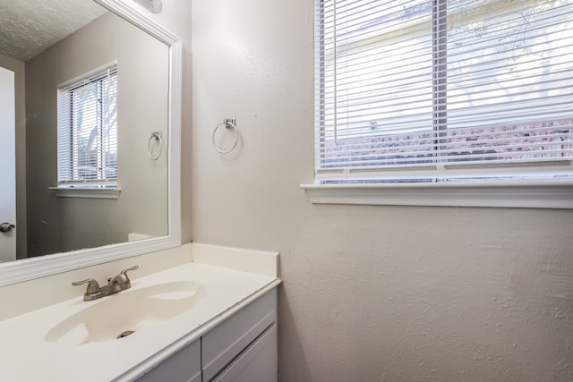 bathroom featuring a textured ceiling and vanity