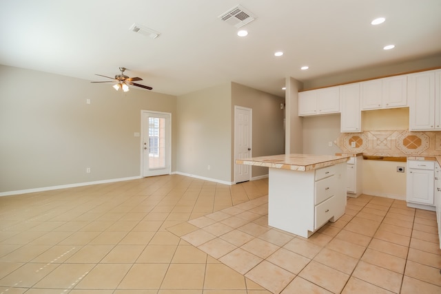 kitchen with light tile patterned floors, white cabinetry, and a kitchen island