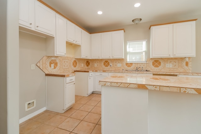 kitchen featuring decorative backsplash, white cabinetry, tile counters, and light tile patterned flooring