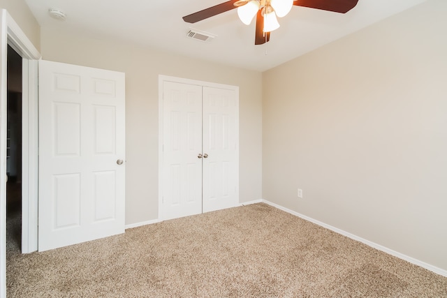 unfurnished bedroom featuring carpet, ceiling fan, and a closet