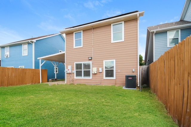 rear view of house with a lawn and central air condition unit