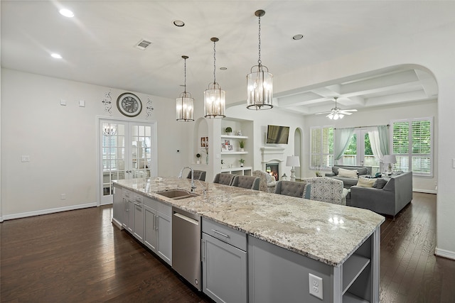 kitchen featuring dishwasher, dark wood-type flooring, a center island with sink, sink, and ceiling fan