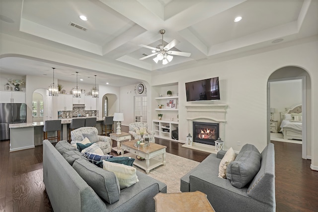 living room featuring beamed ceiling, dark hardwood / wood-style flooring, ceiling fan, and coffered ceiling