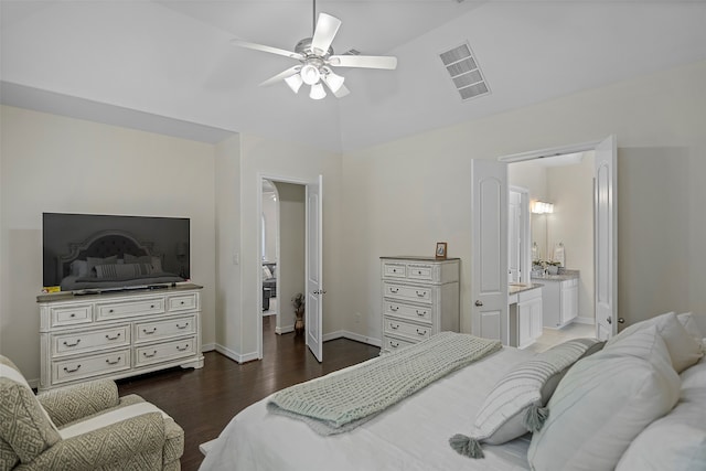 bedroom with ceiling fan, dark hardwood / wood-style flooring, connected bathroom, and vaulted ceiling