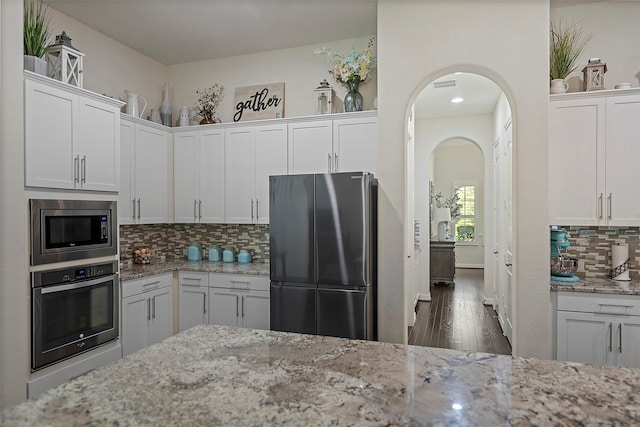 kitchen featuring white cabinetry, light stone countertops, and appliances with stainless steel finishes