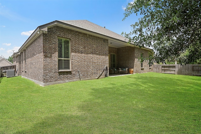 back of house with a yard and central AC unit