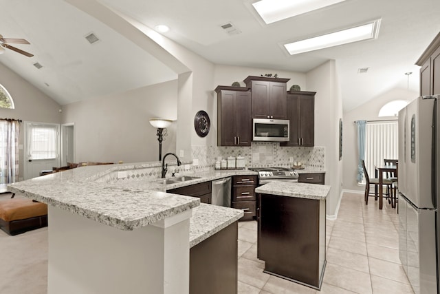 kitchen featuring a center island, lofted ceiling, sink, ceiling fan, and stainless steel appliances