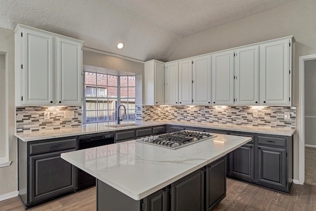 kitchen with black dishwasher, a center island, lofted ceiling, and sink