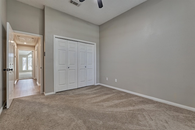 unfurnished bedroom with light carpet, a closet, and ceiling fan