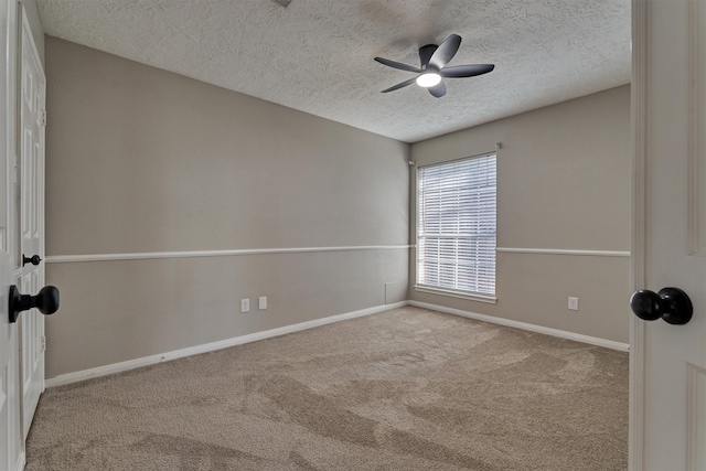 empty room with ceiling fan, light colored carpet, and a textured ceiling