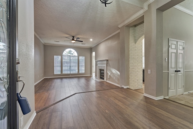 unfurnished living room with hardwood / wood-style floors, ceiling fan, and crown molding