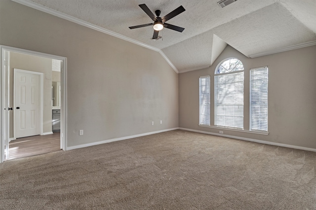 carpeted empty room with vaulted ceiling, ceiling fan, a textured ceiling, and ornamental molding