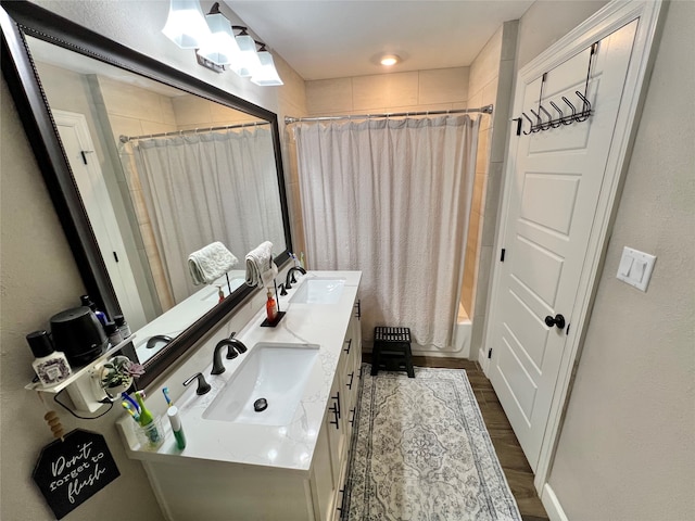 bathroom featuring hardwood / wood-style floors, shower / bath combination with curtain, and vanity