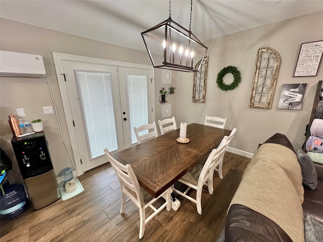 dining room featuring french doors, dark hardwood / wood-style floors, a wall mounted AC, and a notable chandelier