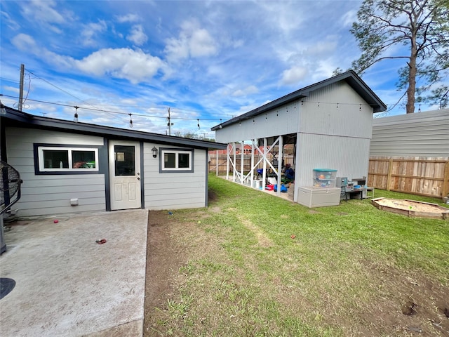 back of house featuring an outbuilding and a yard