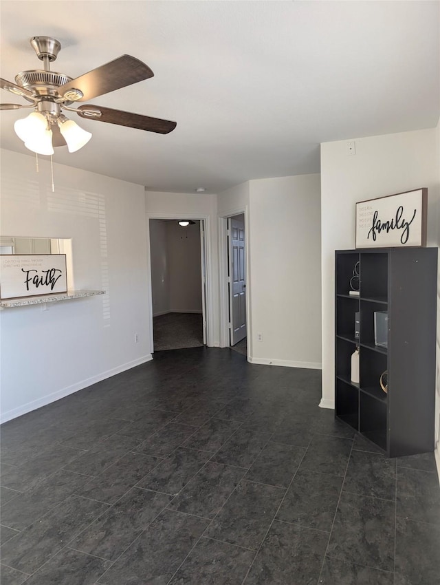 unfurnished living room featuring dark tile patterned floors and ceiling fan