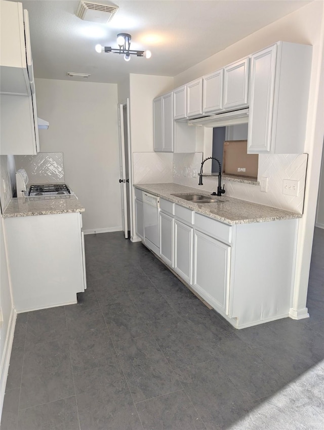 kitchen featuring dishwasher, stainless steel gas stovetop, backsplash, sink, and white cabinetry