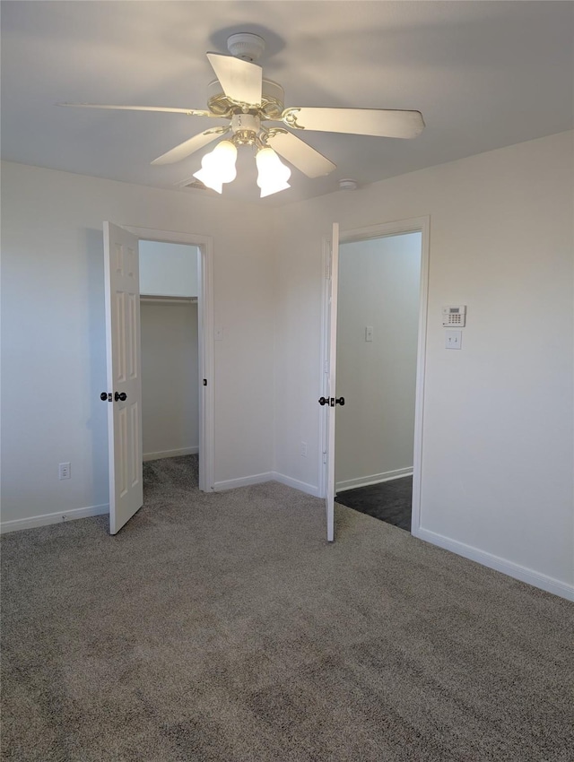 unfurnished bedroom with ceiling fan and dark colored carpet